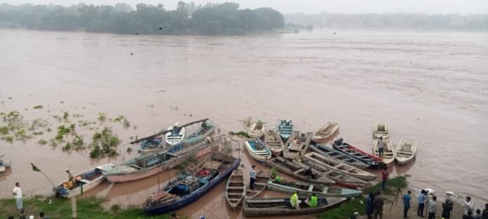 Several boats lined up on River Ravi bank, prepared for emergency use amid warnings of rising waters due to upstream releases from Indian reservoirs.